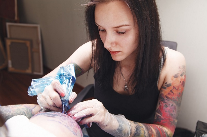 Girl tattoo artist works