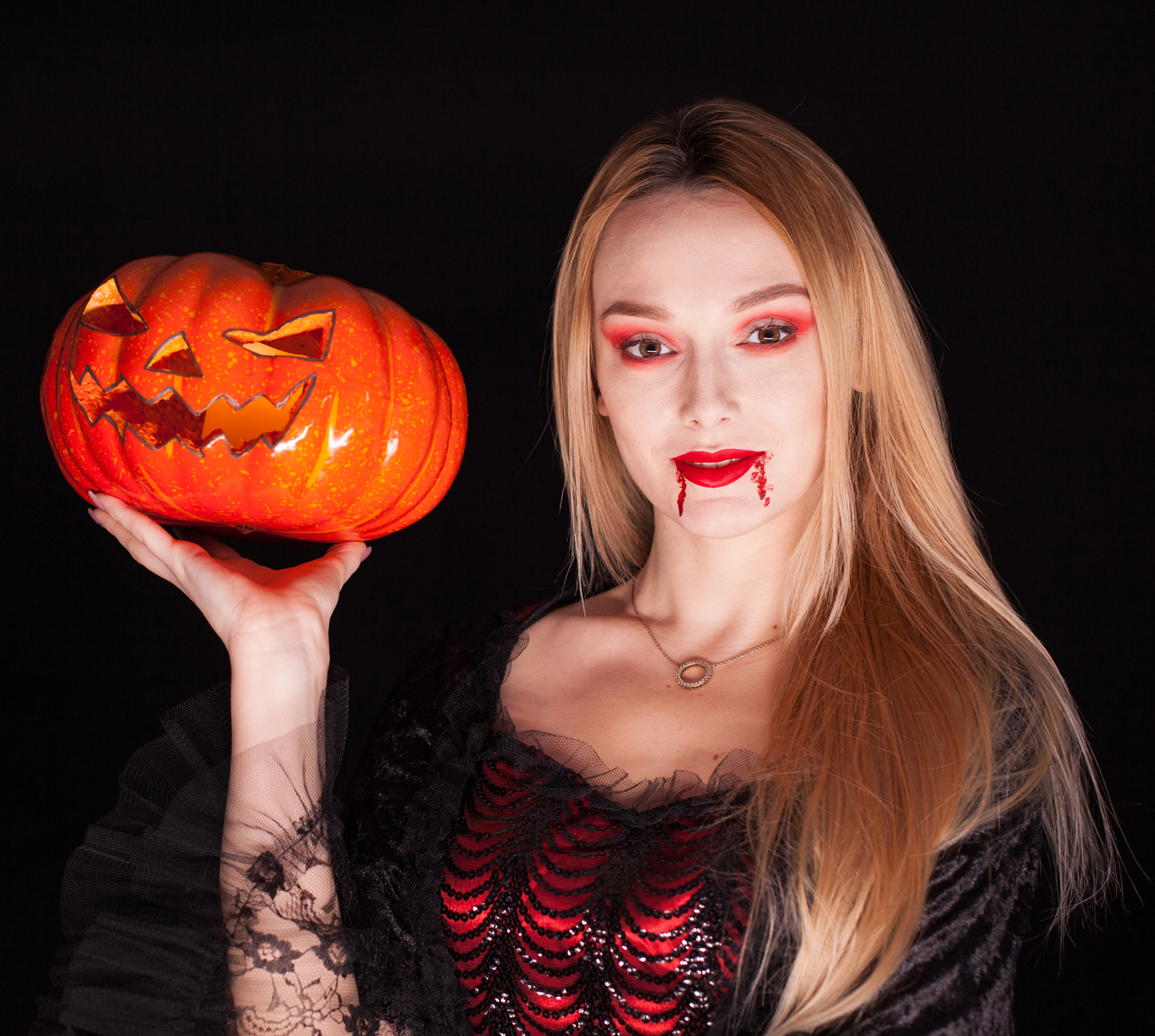 portrait beautiful girl dressed up like vampire holding pumpkin halloween